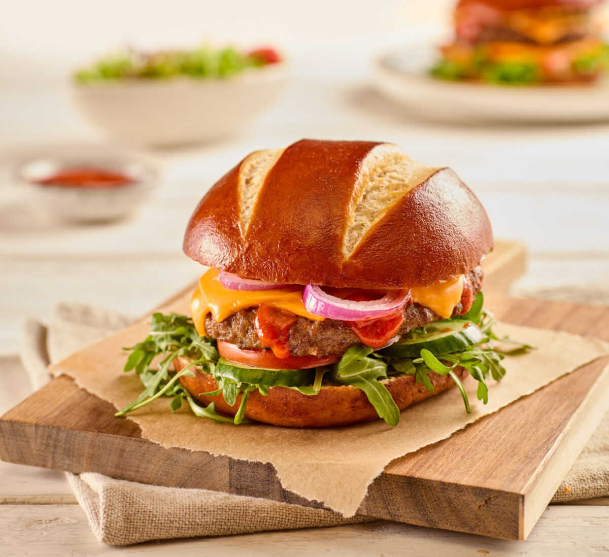 Picture of Pretzel Bun Plated with Cheese Burger Fillings.